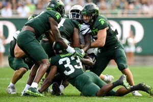 Michigan State's Cal Haladay, right, and the Spartans defense causes a fumble after hitting Akron's Shocky Jacques-Louis during the first quarter at Spartan Stadium in East Lansing. Photo: Nick King/Lansing State Journal / USA TODAY NETWORK