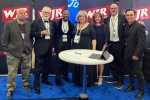 September 16, 2022 ~ The Team, The Team … The TEAM! From left to right: WJR Engineer Ray Templin, WJR Morning Drive Host Paul W. Smith, WJR Administrative Assistant Cameron Knox, WJR Senior News Analyst Marie Osborne, WJR Assistant Program Director Ann Thomas, WJR Senior Account Executive Link Bessert, and WJR Digital Content Coordinator Jonah Phillips present content live from the North American International Detroit Auto Show Charity Preview.