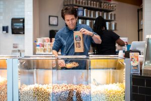 September 19, 2019 ~ Mitch Albom prepares a bag of popcorn at Brown Bag Popcorn at Somerset Collection Mall in Troy. Photo: Junfu Han, Detroit Free Press