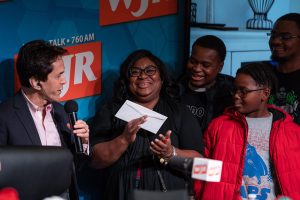 December 12, 2019 ~ LaToya Taylor of Detroit and her family stand on stage as Mitch Albom does a ceremonial handing of the keys after the family received a house from Working Homes/Working Families program during Mitch Albom's Say Detroit Radiothon at Somerset Collection in Troy. Photo: Ryan Garza, Detroit Free Press