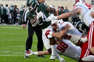 October 15, 2022 ~ Michigan State Spartans running back Elijah Collins drags Wisconsin Badgers tacklers with him on his way to a first down in the fourth quarter at Spartan Stadium. Photo: Dale Young-USA TODAY Sports