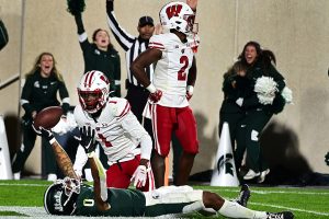 October 15, 2022 ~ Wisconsin Badgers cornerback Jay Shaw and Wisconsin Badgers cornerback Ricardo Hallman look on as Michigan State Spartans wide receiver Keon Coleman holds the ball aloft after catching a touchdown pass in overtime at Spartan Stadium. Photo: Dale Young-USA TODAY Sports