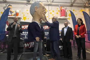 November 4, 2022 ~ The Parade Company President and CEO Tony Michaels presents a papier-mache head of 760 WJR’s Paul W. Smith for induction into the America’s Thanksgiving Parade Big Head Corps. Photo: Ann Thomas
