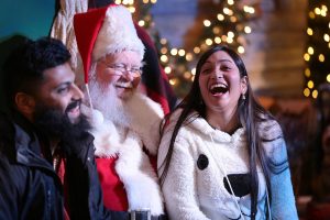 November 16, 2018 ~ Sachin Puthur (left) of Detroit and Sheenam Gupta of Dallas, TX sit with Santa Claus inside One Campus Martius during the annual tree lighting event at Campus Martius Park in Downtown Detroit. Photo: Ryan Garza, Detroit Free Press