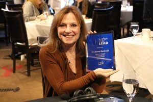 November 19, 2022 ~ Clinical Psychologist Dr. Donna Rockwell displays her award at the 2022 Women Who Lead Honoree Ceremony inside Joe Muer Seafood in Detroit’s Renaissance Center. Photo: Sean Boeberitz / WJR