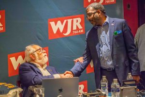 Paul W. Smith shakes hands with WJR Senior News Analyst Lloyd Jackson at the launch of Smith's new show "Focus" on June 20, 2023.