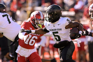 Nov. 18, 2023 ~ Michigan State Spartans running back Nathan Carter (5) runs the ball under pressure from Indiana Hoosiers defensive back Jordan Grier (16) during the first half at Memorial Stadium. Photo: Marc Lebryk ~ USA TODAY Sports