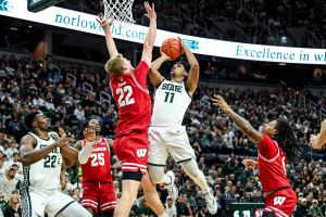 Dec. 5, 2023 ~ Michigan State's A.J. Hoggard, right, scores as Wisconsin's Steven Crowl, left, defends during the first half at the Breslin Center in East Lansing. Photo: Nick King ~ USA TODAY NETWORK