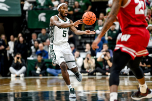 Dec. 5, 2023 ~ Michigan State's Tre Holloman passes the ball against Wisconsin during the second half at the Breslin Center in East Lansing. Photo: Nick King ~ USA TODAY NETWORK