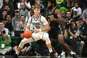 Dec. 18, 2023 ~ Michigan State Spartans center Carson Cooper (15) dribbles the ball against Oakland Golden Grizzlies forward Tuburu Naivalurua (12) during the first half at Jack Breslin Student Events Center. Photo: Dale Young ~ USA TODAY Sports
