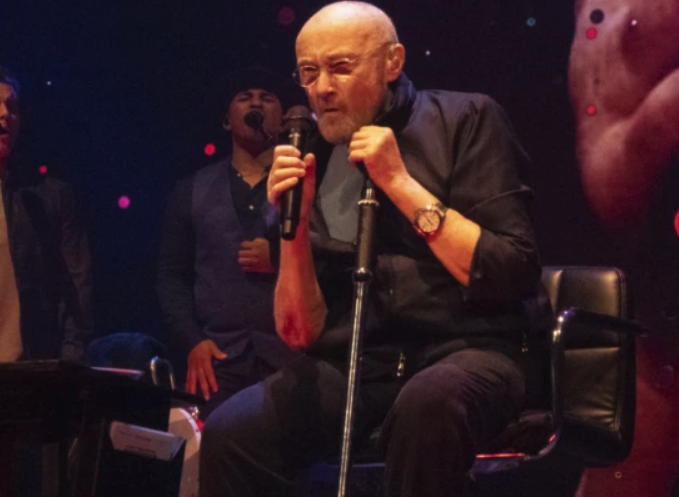 Frail Phil Collins begins Genesis farewell tour in Birmingham, singing from chair onstage