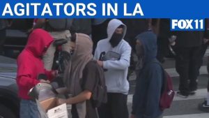 FOX 11 Catches Masked Group Handing Out Riot Gear