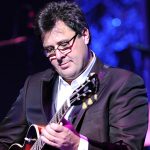 Watch Vince Gill Honor Mac Davis With Beautiful Rendition of “In the Ghetto” at the Opry