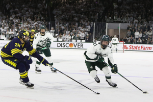 March 23, 2024 ~ Michigan State's Red Savage moves the puck against Michigan's Steven Holtz during the Big Ten Hockey Championship at Munn Ice Arena in East Lansing. Michigan lost 4-5 in overtime. Photo: Matthew Dae Smith ~ USA TODAY NETWORK
