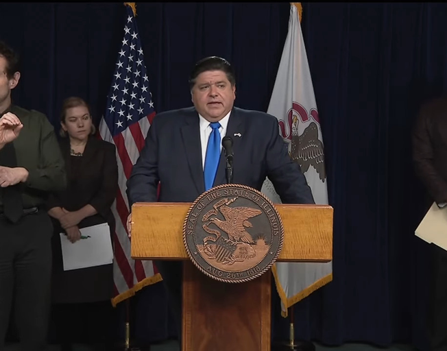 IL Governor J.B. Pritzker at a press conference (Photo credit: YouTube)