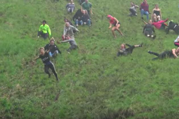 Watch These People Get Their Asses Kicked Chasing a Wheel of Cheese Down a Hill [VIDEO]