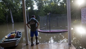 David Key looks at the back yard of his flooded home in Prairieville, La., Tuesday, Aug. 16, 2016. Key, an insurance adjuster, fled his home as the flood water was rising with his wife and three children and returned today to assess the damage. (AP Photo/Max Becherer)