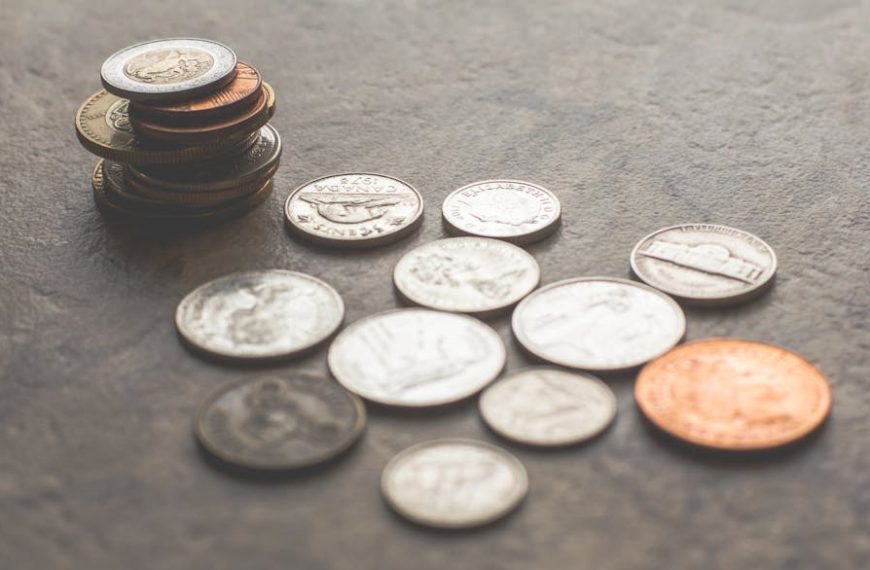 Assorted foreign coins stacked and scattered on a textured surface.