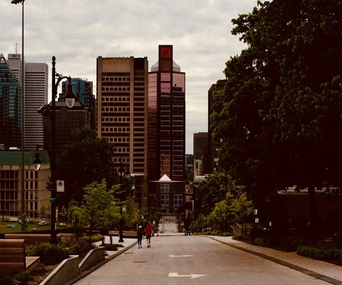 Montréal city street view with skyscrapers, trees, and people walking. Perfect for urban themes.