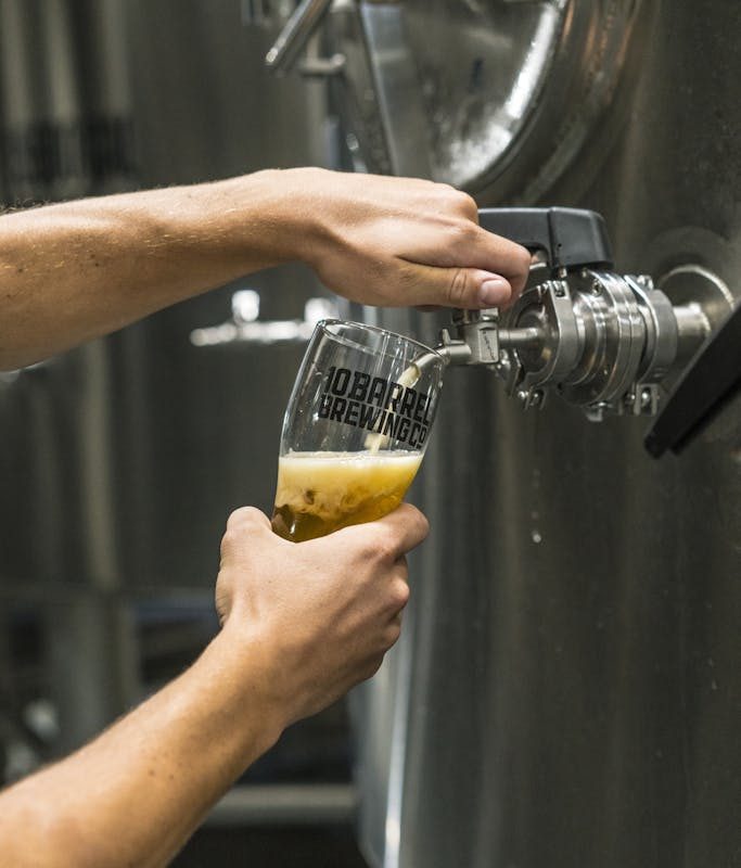 Person Filling Up Beer Glass from Tap Machine