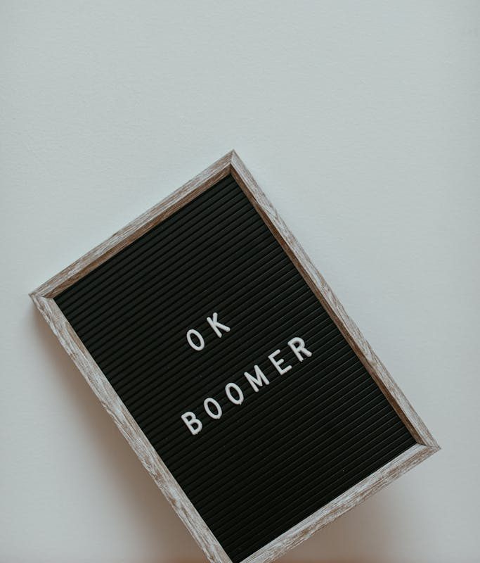 A Letter Board Leaning on a White Wall on a Wooden Surface