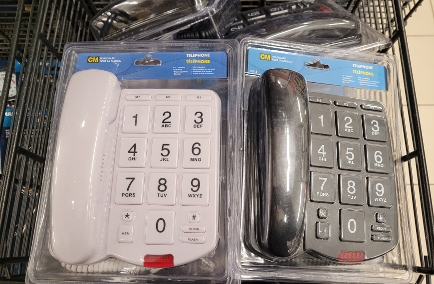 2 landline phones, one black, one white, both with absolutely enormous number buttons