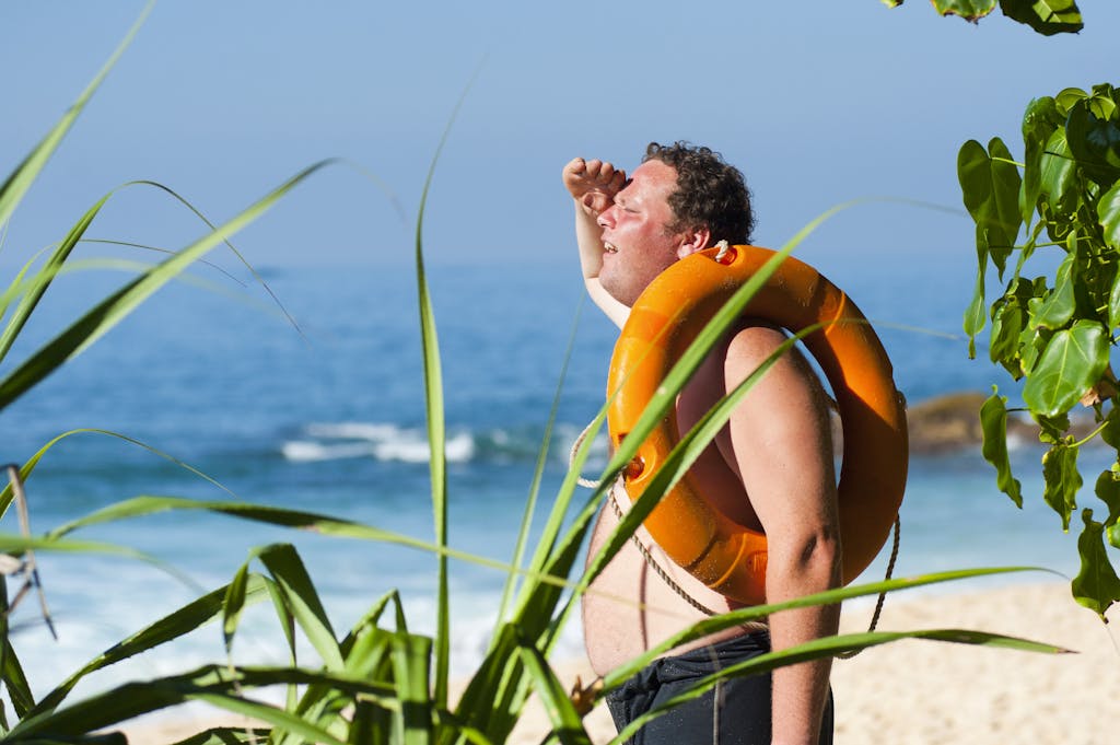 Orange Safety Ring on Man Shoulder Near Body of Water