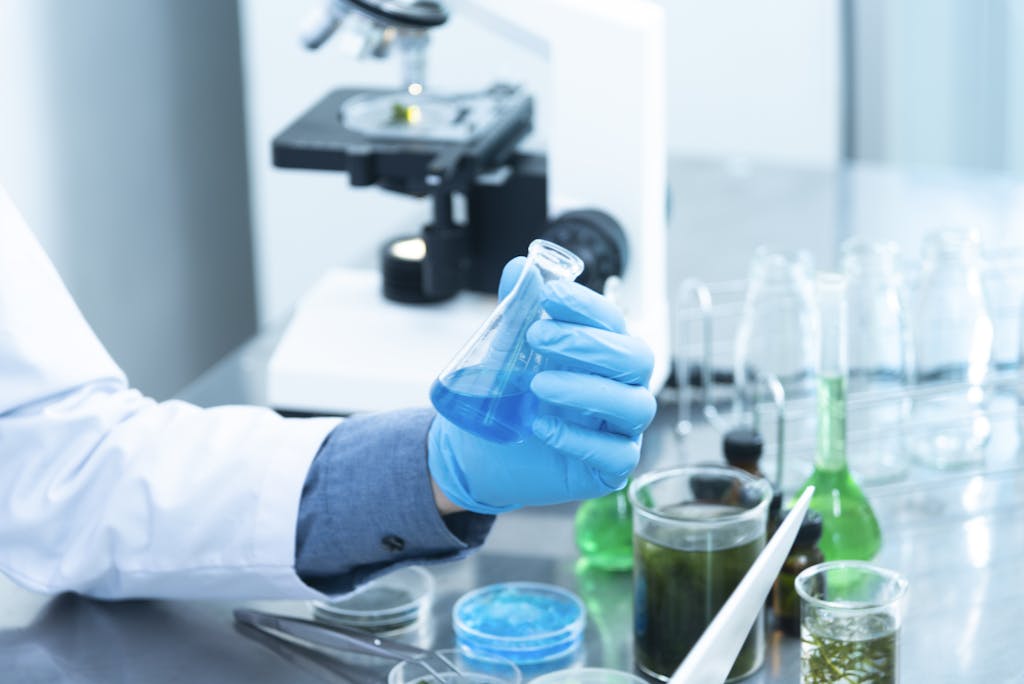 Person Holding Laboratory Flask