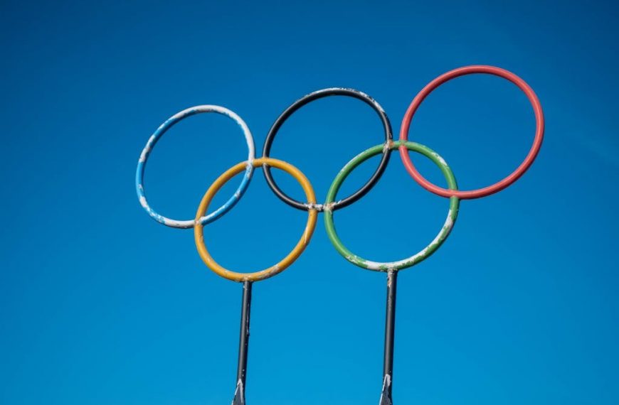 Olympic rings on poles against a blue sky