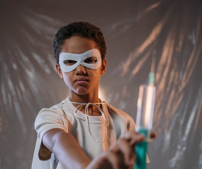 A Boy Wearing a Mask Holding a Syringe